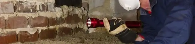 Pest control technician inspecting a crawl space for ant activity and entry points in West Palm Beach, FL
