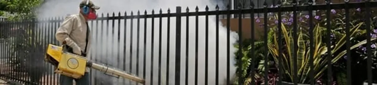 Mosquito control technician fogging a yard perimeter for mosquito reduction in West Palm Beach, FL